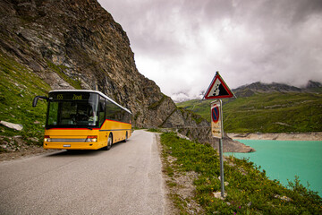 yellow coach of public transportation service. Busstop on top of Lac de Moiry in the Swiss Alps. At Grimentz Vallis, Switzerland.