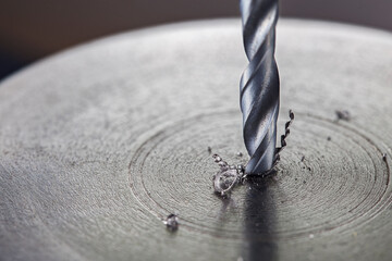 metal drill bit make holes in steel billet on industrial drilling machine. Metal work industry....