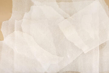 White plastic foam sheet pieces on cardboard background. Closeup of torn foam polyethylene pieces.