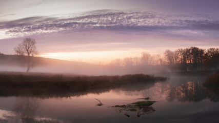 Fototapeta na wymiar Autumn landscape fog over river and sky with rising sun