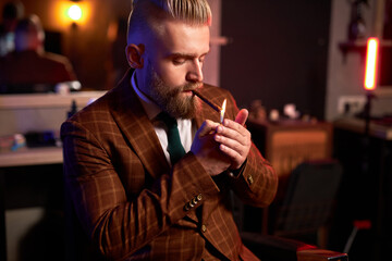 rich young caucasian business man in suit smoke a cigar while sitting alone in dark room, enjoy,...