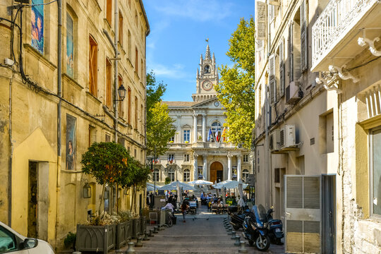 Fototapeta The main square and Avignon City Hall on a summer day with a large cafe with outdoor seating and umbrellas filled with tourists in Avignon France