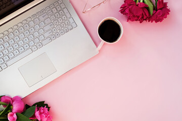 Obraz na płótnie Canvas Laptop, peonies and coffee on pink tabl