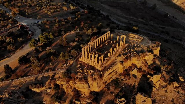 Aerial POI footage of the Temple of Hera, (Tempio di Giunone) in the Valley of Temples (Valle dei Templi), during a spectacular sunset in Sicily, Italy.