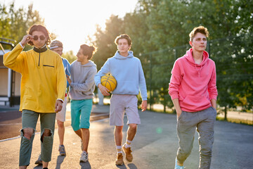 friendly group of caucasian teenagers boys ready to play basketball, athletic young guys full of...
