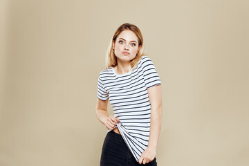 Obraz premium Cheerful woman striped t-shirt studio beige background lifestyle emotions