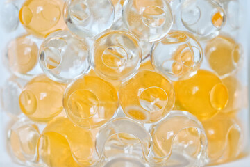 Lots of yellow and clear gel scent beads. They look like magic fish eggs. Hygiene and health. Close-up. Shallow depth of field.