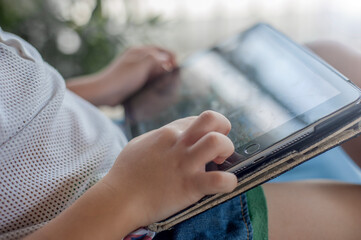 Little kid's using Digital Touchscreen Phone Tablet computer playing games.