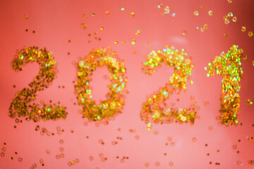 Blurry 2021 numbers. Shiny Golden glitters. Red background. New Year wallpaper