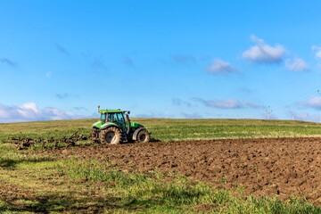 Obraz premium Ploughing in the fields. Tractor plows a field. Autumn agricultural landscape in the Czech Republic. Autumn morning in the field.