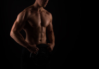Obraz na płótnie Canvas Muscular male torso of fit bodybuilder on black background