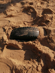 Car tire sticking out of the sand