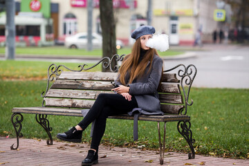Vaping teenager. Young pretty white caucasian teenage girl in gray beret smoking an electronic...