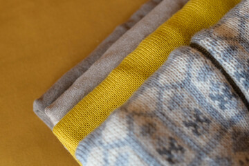 New cozy clothes for cold autumn days - sweaters and turtlenecks in gray, beige and yellow colors.