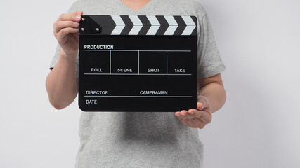 A man wear gray t-shirt and hand is holding black Clapper board or movie slate. it use in video...