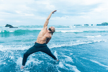 Athlete man practicing on a beach shore