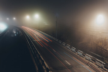 Fototapeta na wymiar Foggy misty night. Road junction illuminated by street lights