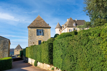 Fototapeta na wymiar Green street in the medieval historical village leading to the castle Chateau de Marqueyssac. Dordogne, France.