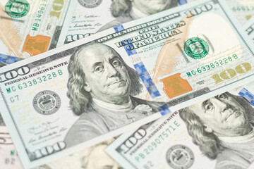 100 Dollars bill and portrait Benjamin Franklin on USA money banknote. Hundred dollar bills on wooden background..