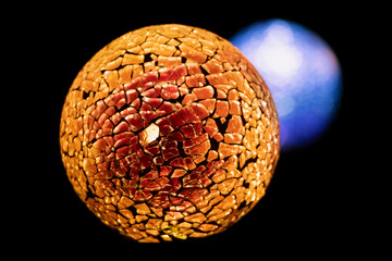 Golden planet with white blue star in deep black space.