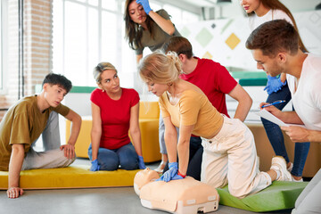 group of young diverse people practice first aid training by hand, first aid course in CPR dummy....