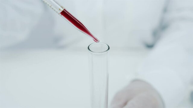 Blood sampling for medical analysis. Research on hormones. Getting the vaccine. The doctor drips blood from a pipette into a test tube.