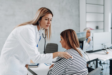 Fototapeta premium Female doctor examining diabetic woman in hospital.