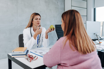 Owerweight woman talking with nutritionist about nutrition and weight loss.