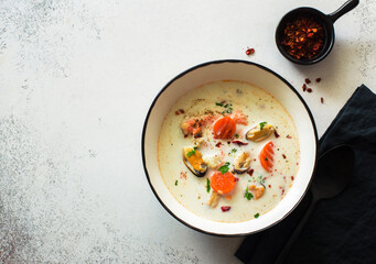 Bowl of mussels, red fish, vegetables and coconut milk Asian soup