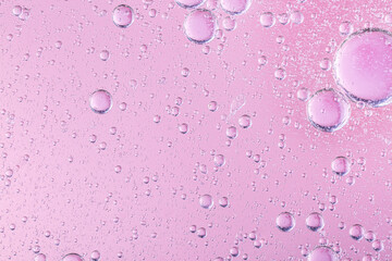 oil with bubbles on coral background. Pink Abstract space background. Soft selective focus. macro...