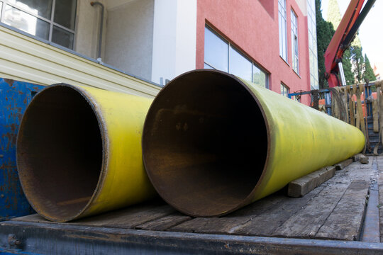 New pipes to replace the heating main. Steel pipes in a truck. Large water pipes close-up.