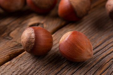 Two hazelnuts on a wooden background. Hazelnut in shell close-up.
