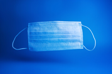 blue disposable medical mask on a blue background