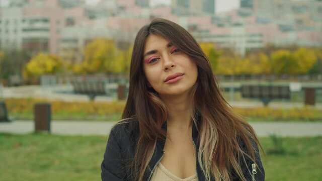 Good Looking Young Lady looks at the camera on the city street Red Helium4K