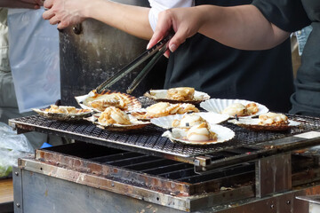 Grilling a scallop shell (hotate), famous japanese street food