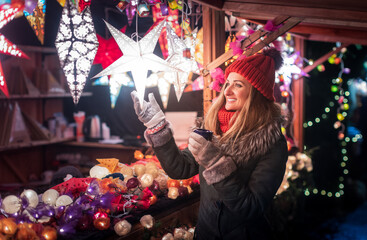 Obraz na płótnie Canvas Woman buying decoration and baubles on Christmas market