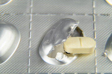 Extracción de una pastilla.
Medicación en forma de pastilla extraída de un blíster para su consumo.
