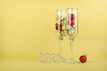 New year's composition with an empty glass of champagne on a yellow background