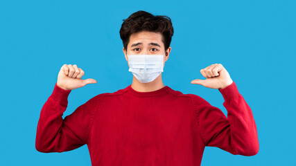 Asian guy in medical mask pointing at himself