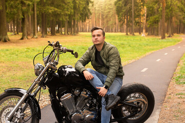Fototapeta na wymiar Beautiful man sits on a motorcycle, road