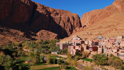 Small Berber village located in a green oasis valley with fields and palm trees near Tinghir, Morocco in the south of Atlas Mountains with the entrance of Todgha Gorge, a popular tourist destination.