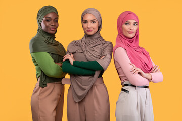 Three Diverse Muslim Ladies In Hijab Standing Together, Yellow Background