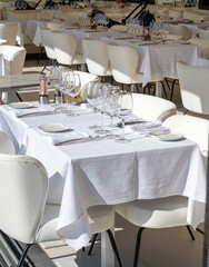 Before lunch time, empty cafes with served tables and tablecloths waiting for guests in Saint-Tropez, Provence, France