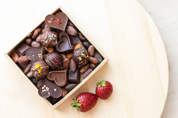 Chocolate bars handmade with strawberries and pistachios on a black background. Craft vegan chocolate