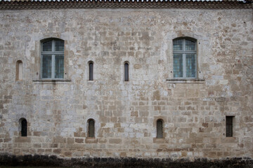 Front view of facade of an abbey. Regular facade with arched windows. Facade from sandstone.