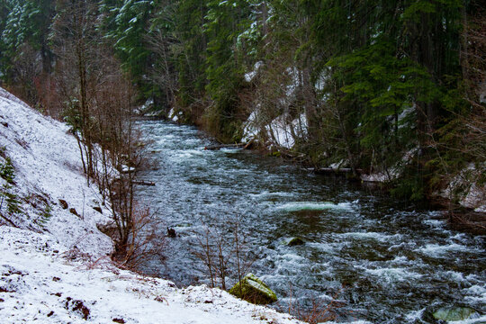 Creek with flowing water and snow