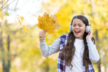 Trendy beauty. childhood happiness. beauty and nature. happy kid wear headphones. teen girl listen music on the way to school. child walk in autumn forest. fall maple leaves in park. online education