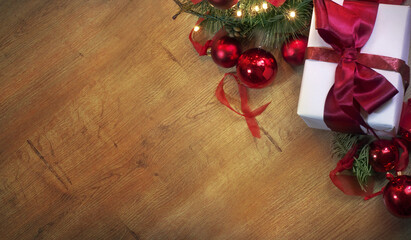 Top view of a Christmas decorated background with a present, tree, and flashing lights on a wooden table. With copy space for your new year's wishes, text