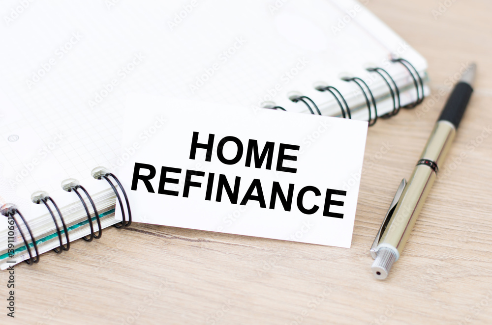 Poster business card with home refinance text on the table, next to a notebook and a pen.