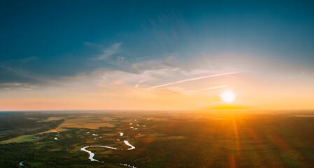 Belarus. Aerial View. Beautiful Sunset Sun Sunshine Above Summer Green Forest And River Landscape In Sunny Evening. Top View Of European Nature From High Attitude In Summer Sunrise. Bird's Eye View